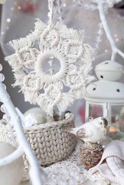Beautiful New Year's decor using macrame technique. Handmade, Macrame cord snowflake hanging on a white branch - Foto, Imagen