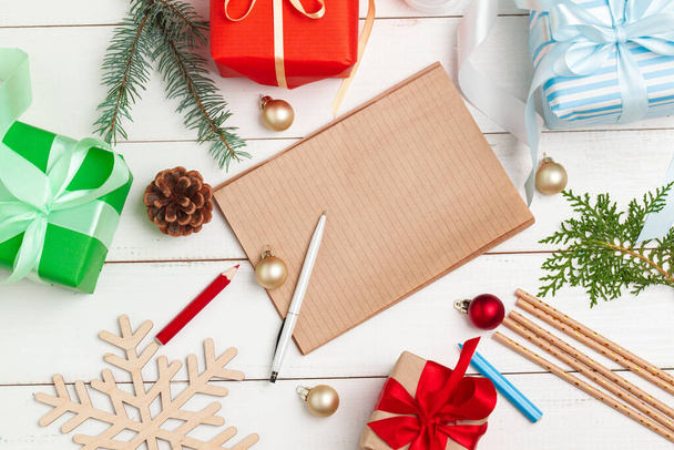 Schreiben von Weihnachtsgrußkarten. Notizblock mit Stift auf dekoriertem Holztisch öffnen - Foto, Bild
