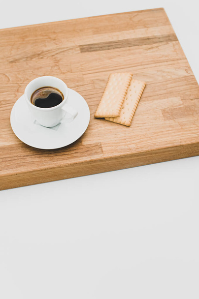 espresso coffee and biscuits on a wooden chopping board and white background with copy space - Foto, Imagen