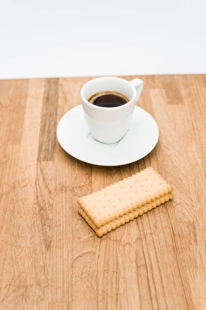espresso coffee and biscuits on a wooden chopping board and white background with copy space - Фото, изображение