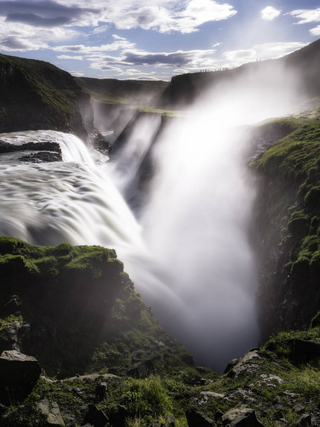 A vertical shot of a scenic waterfall flowing down the high cliff in Iceland - Foto, Bild
