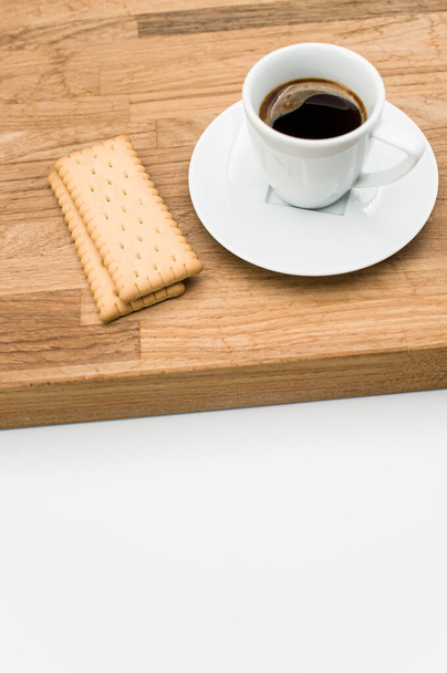 espresso coffee and biscuits on a wooden chopping board and white background with copy space - Foto, Imagen