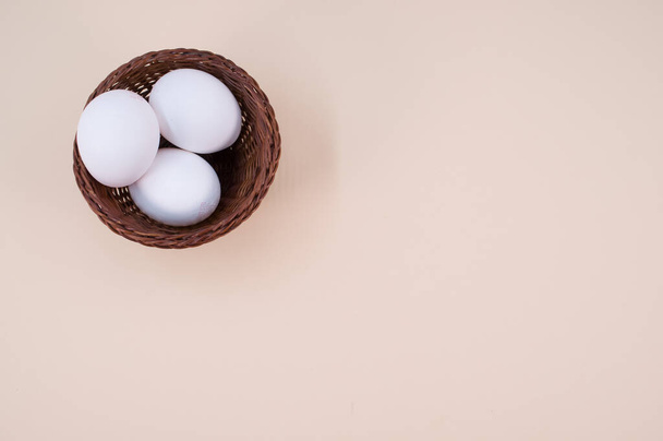 organic white eggs in a canister on a beige surface with copy space for text - Photo, image