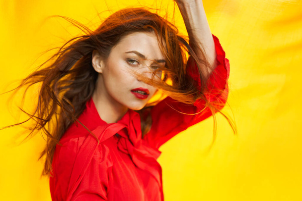 cheerful woman in red dress posing in nature yellow cloth - Foto, Imagen