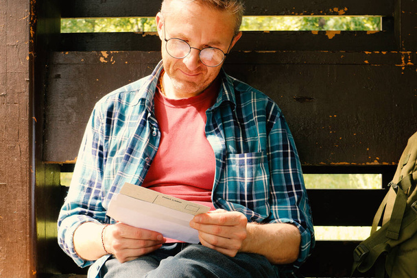 senior man reading book in the park - Foto, Imagen