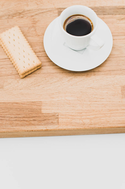 espresso coffee and biscuits on a wooden chopping board and white background with copy space - Valokuva, kuva