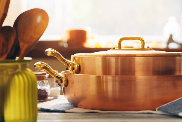 Copper cookware with wooden kitchen utensils close up - Fotoğraf, Görsel