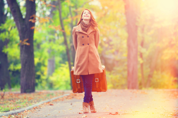 roodharige meisje met koffer in herfst buiten - Foto, afbeelding