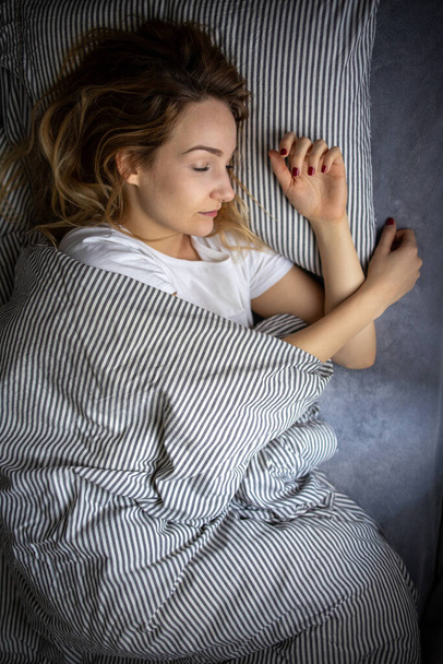 Досить, молода жінка спить у ліжку пізно вранці на вихідних - компенсує відсутність сну
 - Фото, зображення
