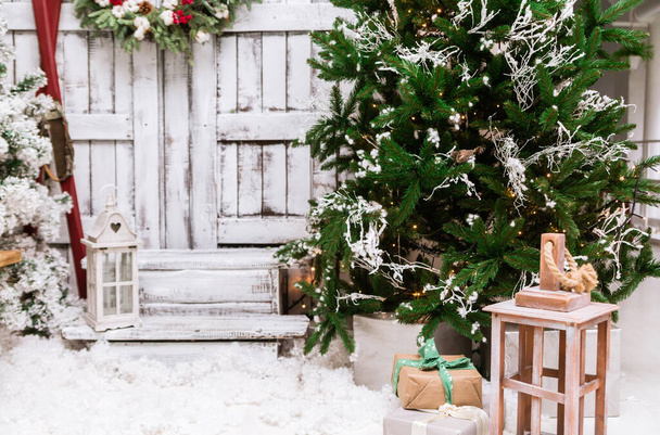 Kerst versierd huis en tuin. Studio decoratie in nieuwjaarsstijl. Sneeuw overdekte binnenplaats van een houten huis of huisje. Achtergrond voor fotograaf - Foto, afbeelding