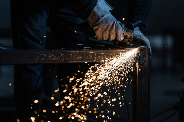 Man working on iron with grinder. Man at work. Sparkles and fire from grinder cutting. Grinder. Worker. - Foto, Bild