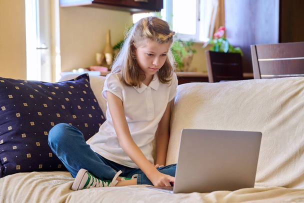 Κορίτσι παιδί με φορητό υπολογιστή στο σπίτι στον καναπέ - Φωτογραφία, εικόνα