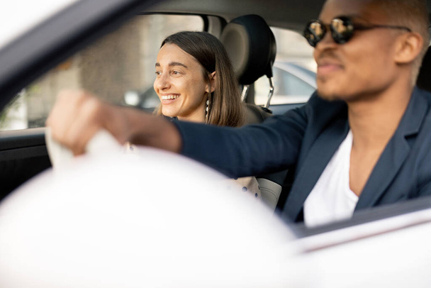 Happy multiracial couple driving at car together - Фото, изображение