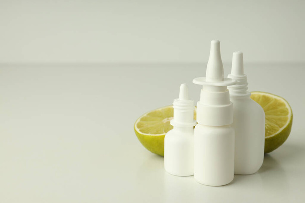 Prázdné láhve nosního spreje a půlky vápna na bílém stole - Fotografie, Obrázek
