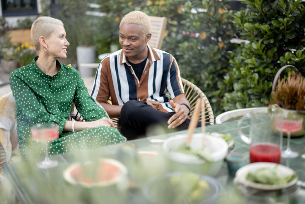 Pareja multiracial cenando en su patio trasero - Foto, Imagen