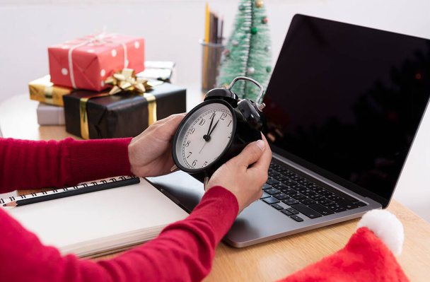 Empresária segurando uma contagem regressiva do relógio ano novo na mesa de escritório no dia de ano novo 2022. - Foto, Imagem