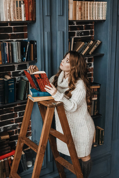 Žena se dívá do knih na knihovně. - Fotografie, Obrázek