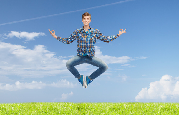 χαμογελαστός νεαρός άνδρας άλματα στον αέρα - Φωτογραφία, εικόνα