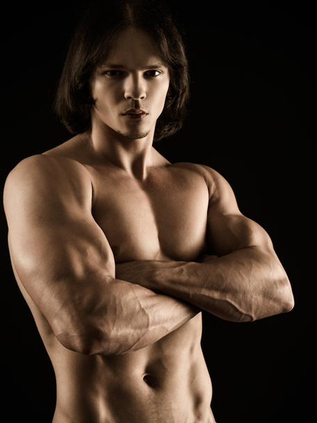 Muscular young man with arms crossed - Фото, изображение