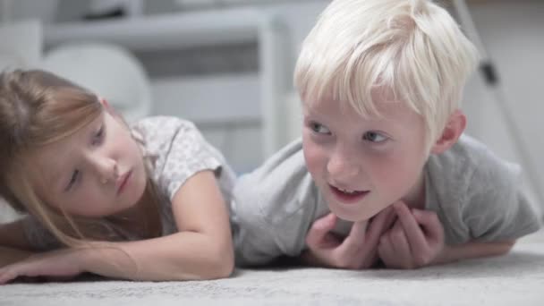 Eine Nahaufnahme von zwei Kindern, Geschwistern und Brüdern, liegt zu Hause auf dem Boden und langweilt sich während der Quarantäne in Russland. - Filmmaterial, Video