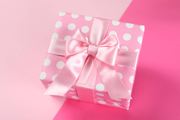 Rosa Geschenkbox auf zweifarbigem Hintergrund - Foto, Bild