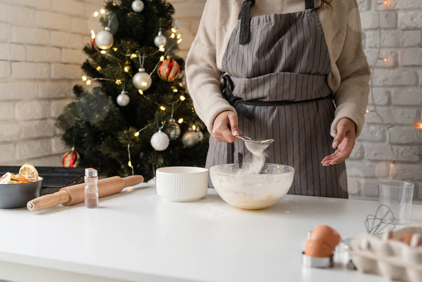 キッチンで笑顔の女性ベーキングクリスマスクッキー - 写真・画像