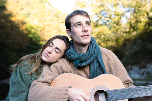 Романтична пара грає на гітарі на відкритому повітрі
 - Фото, зображення