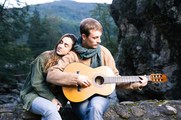 Romantyczna para grająca na gitarze w parku - Zdjęcie, obraz