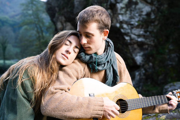 Romantico giovane coppia suonare la chitarra all'aperto in un parco - Foto, immagini