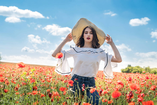 Schöne ukrainische Dame allein mit Strohhut auf Blumen Mohnfeld, sexy, sonniger Tag - Foto, Bild