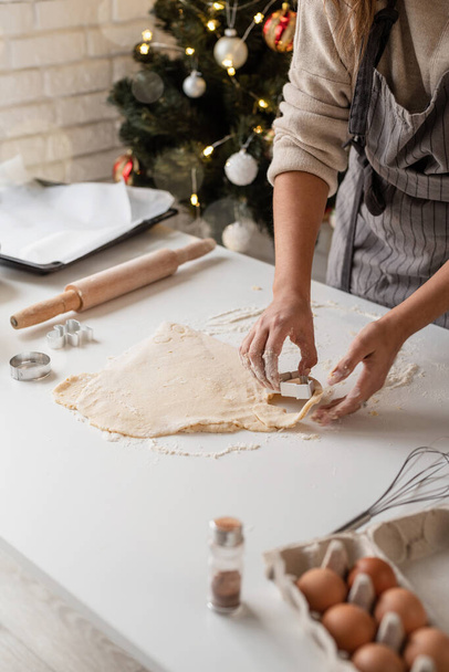 Улыбающаяся женщина на кухне печет рождественское печенье - Фото, изображение