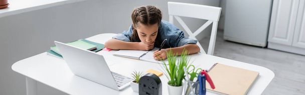 Gyerek írás notebook közelében laptop és írószer otthon, banner  - Fotó, kép
