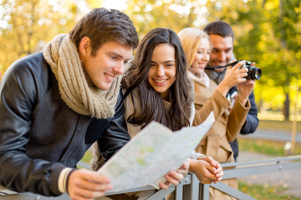 group of friends with map and camera outdoors - Photo, image