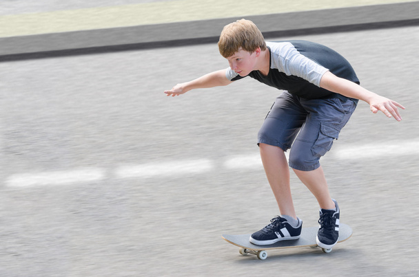 Young skater teenager guy in motion moving on skateboard - Zdjęcie, obraz