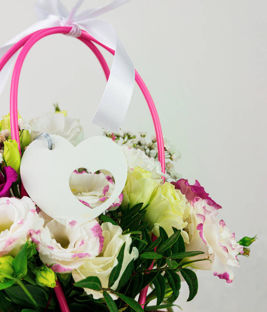 Hermoso ramo de flores de Eustoma Gypsophila blanco en fondo claro cesta de pastel rosa. Floral regalo floreciente fondo de pantalla, Mujeres Madres día tarjeta de felicitación invitación de boda Banner festivo espacio de copia - Foto, imagen
