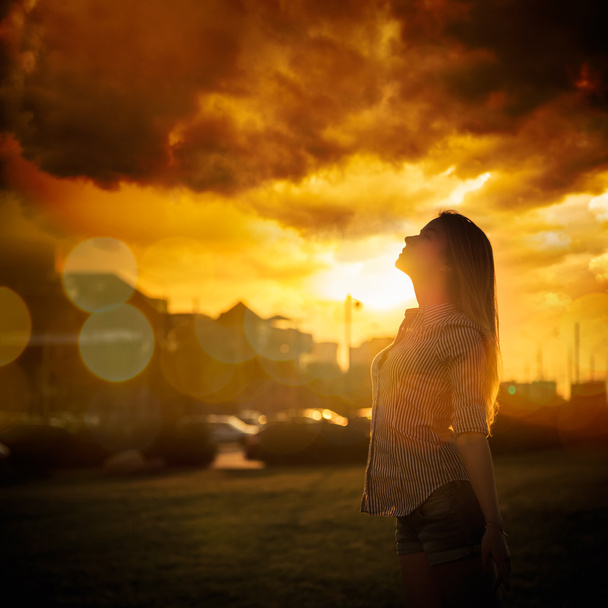 silhouet van jonge vrouw bij stedelijke zonsondergang - Foto, afbeelding