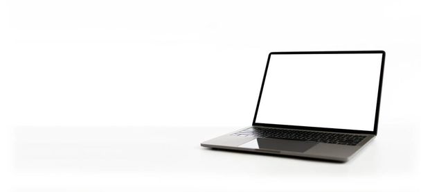 Clip path, Blank white screen laptop on a white table in the room. Working from home concept using technology, notebook, internet. Copy space on left for design, Close up, Gray, and blurred background - Fotografie, Obrázek