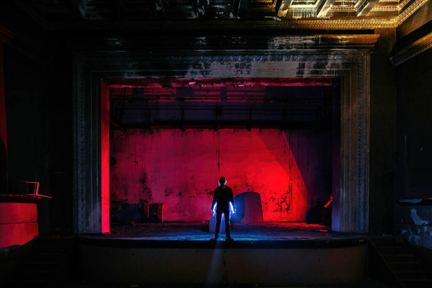 Man on the stage of creepy abandoned theater. - Foto, afbeelding