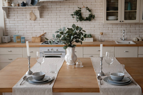 Μοντέρνο κομψό λευκό και ελαφρύ ξύλο σκανδιναβικό εσωτερικό κουζίνα με αξεσουάρ κουζίνας. - Φωτογραφία, εικόνα