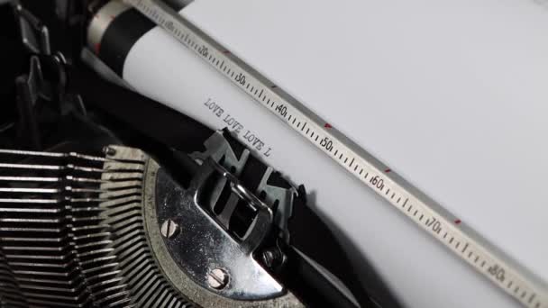 Staromodna maszyna do pisania z rocznika, wielokrotnie wymawiająca słowo "miłość", staromodny list miłosny, powieść lub koncepcja ślubu. - Materiał filmowy, wideo