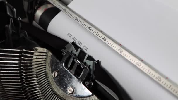 Eine altmodische alte Schreibmaschine, die das Wort Sex mehrmals buchstabiert, altmodische Liebesbriefe oder Romanvorlagen - Filmmaterial, Video