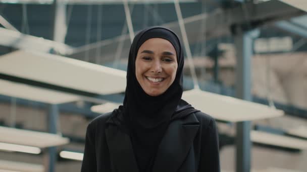 dama islámica usando hiyab sonriendo a cámara de pie en el cargo - Imágenes, Vídeo