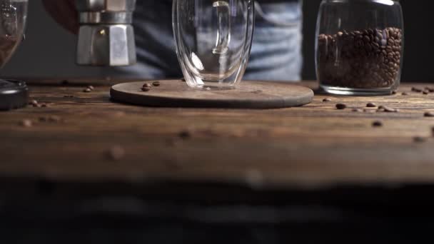 Bereiding van heerlijke zwarte koffie Italiaanse moka. Geyser koffiezetapparaat op een houten tafel op een donkere achtergrond - Video