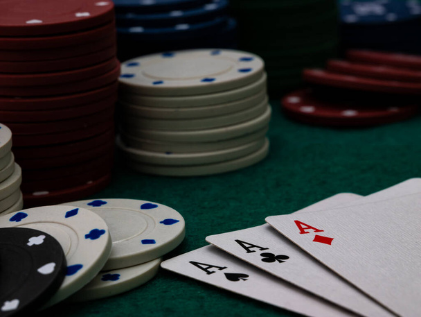 ポーカーゲームテーブル緑のテーブルの上にチップを演奏する3つのエース - 写真・画像