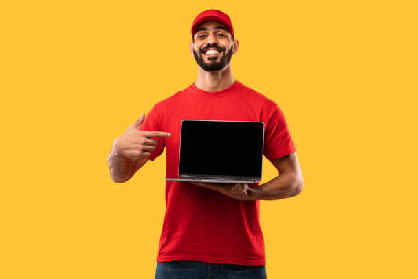 黄色の背景にノートパソコンの広告ウェブサイトを表示配達男 - 写真・画像