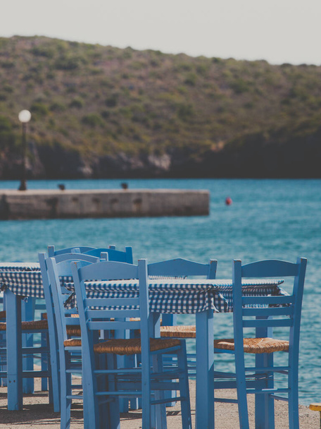 Seaside blue table and chairs open cafe outdoor restaurant in Greece on sea shore. Summer vacation on resort. - Foto, Imagem