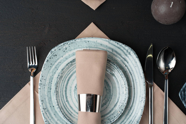 Table setting. Plates with abstract pattern on black table - 写真・画像