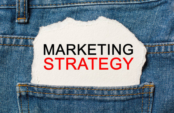 Marketing Strategy on torn paper background on jeans business and finance concept - Zdjęcie, obraz