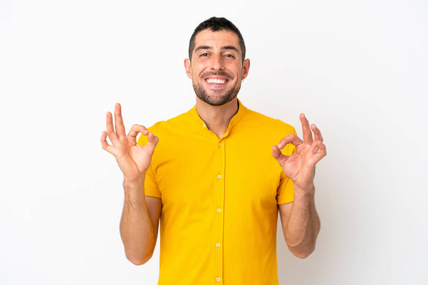 Jeune bel homme caucasien isolé sur fond blanc montrant ok signe avec deux mains - Photo, image