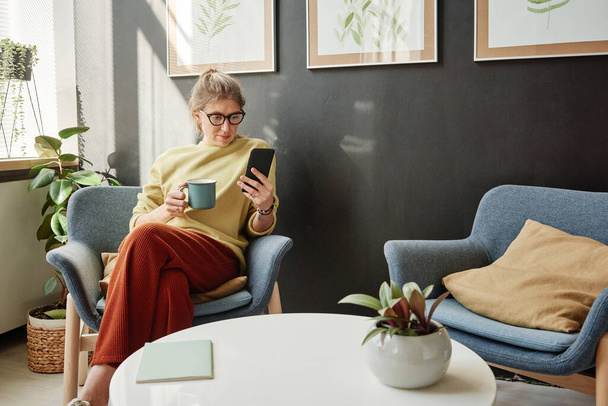Žena relaxace s kávou a mobilním telefonem - Fotografie, Obrázek